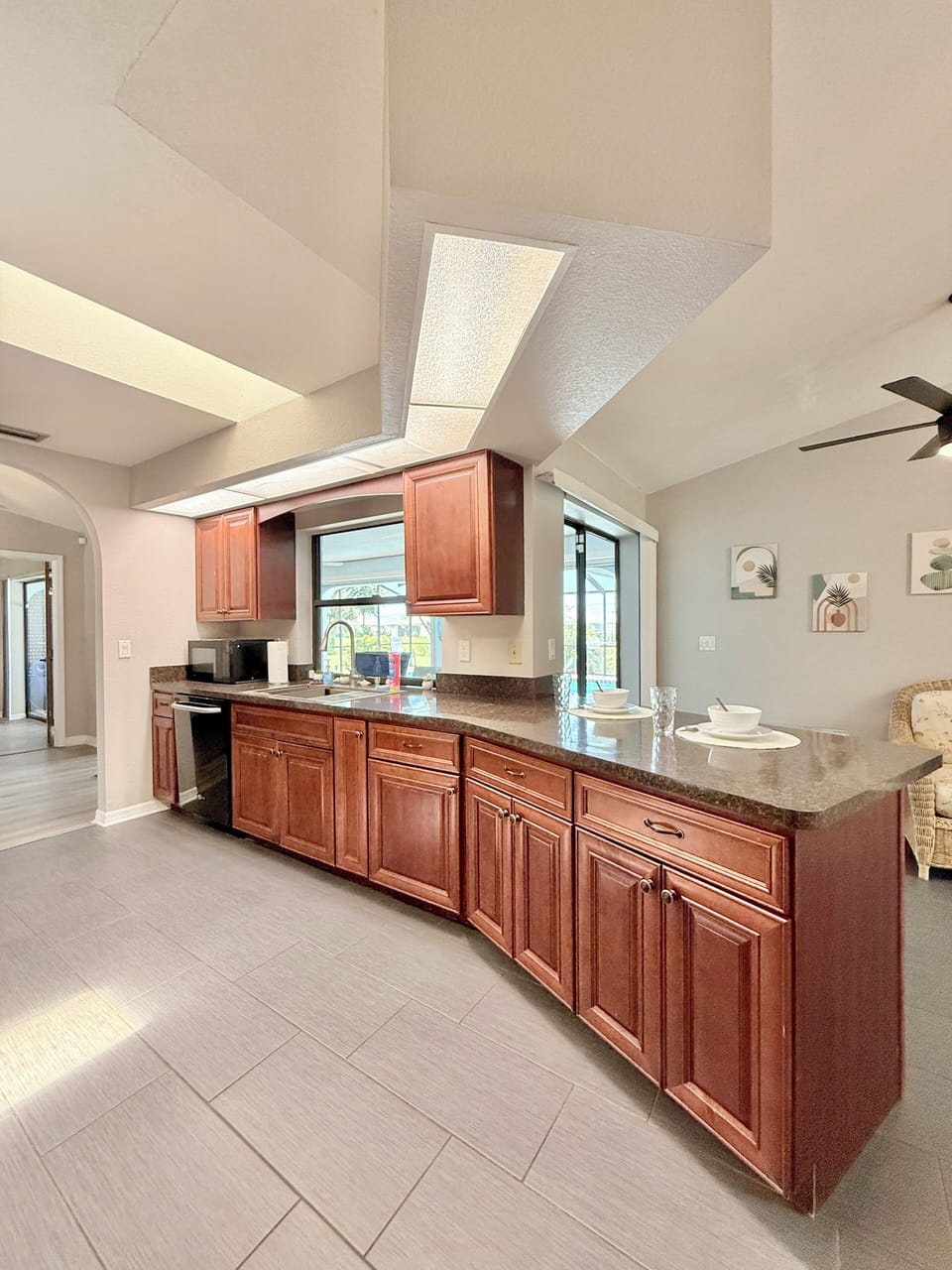 Kitchen features essential appliances, also includes a counter with 2 bar stools