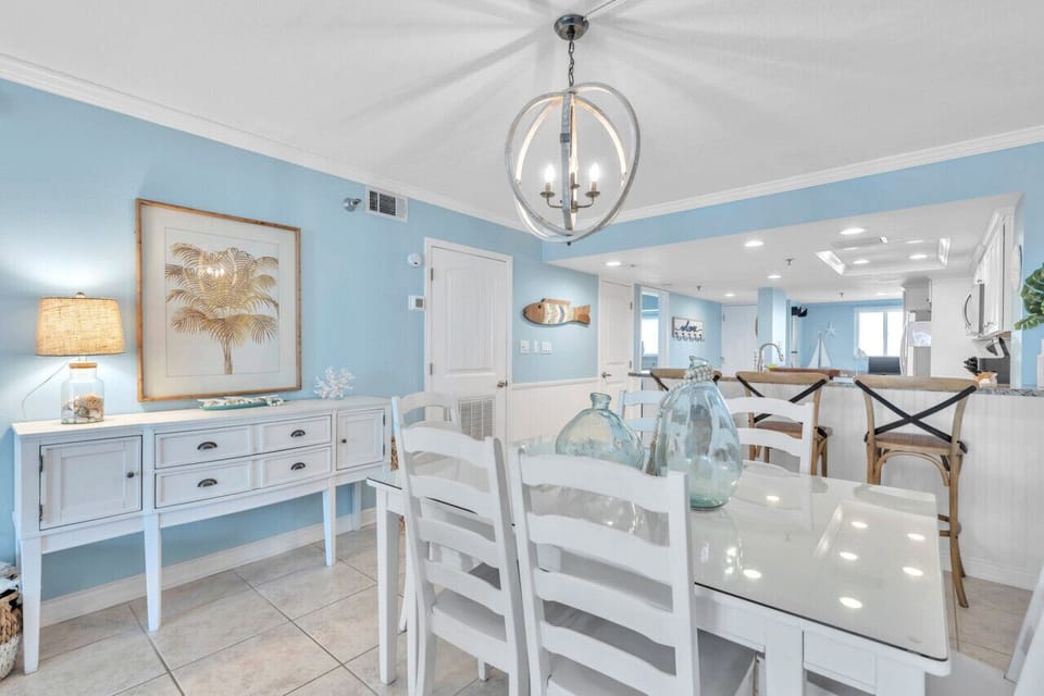 Bright dining space accented by coastal decor & soft blue tones throughout.