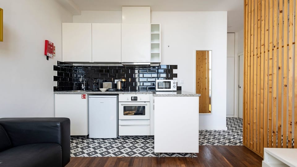 A compact yet functional kitchenette equipped with essential appliances like a mini-fridge, microwave and coffee maker. #modern #practical
