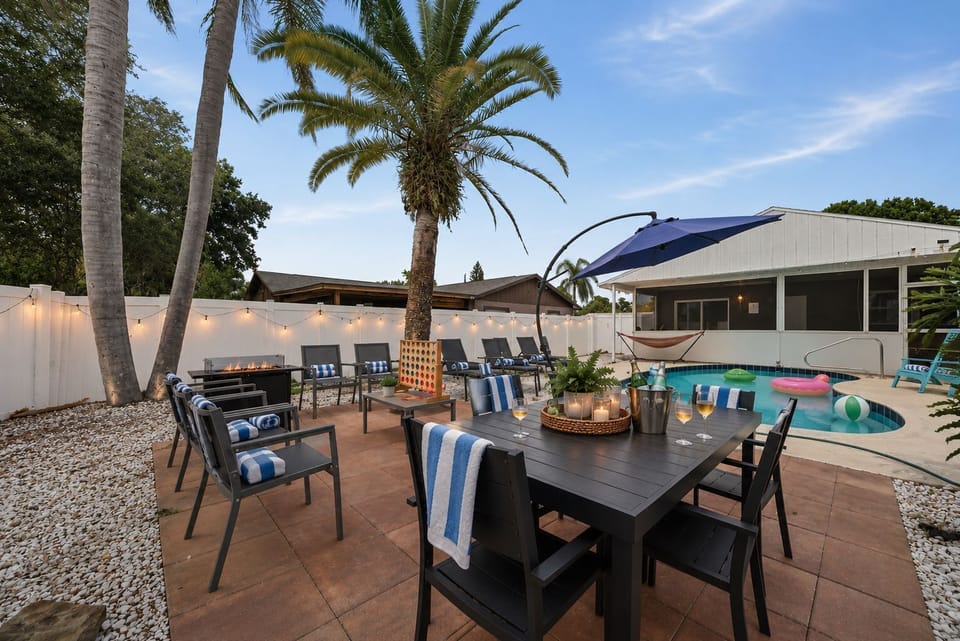 Gather, grill, and make memories in this incredible backyard oasis! Enjoy outdoor dining, the BBQ, fire table, private pool, hot tub, & endless family fun just minutes from the beach. Perfect for your next getaway! #BestFamilyAirbnb #BradentonAirbnd