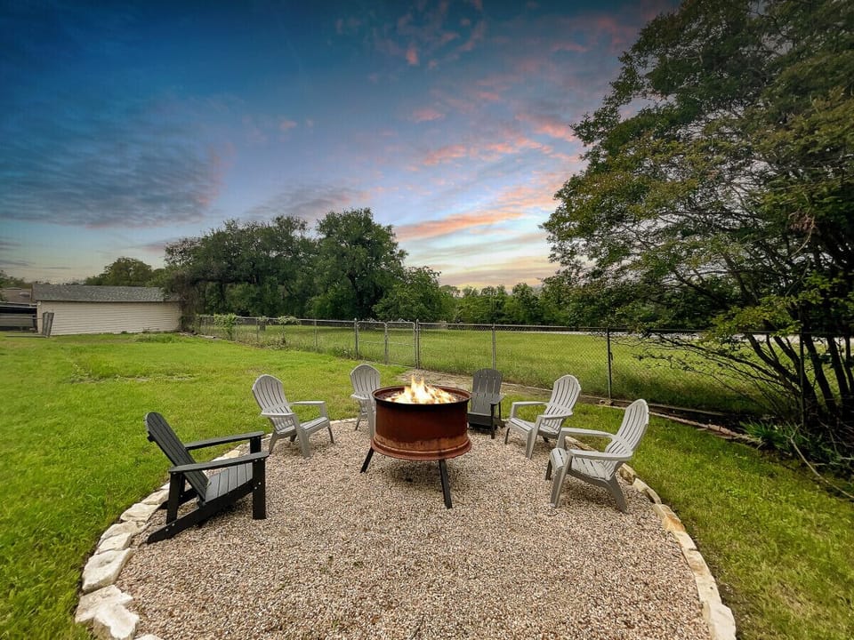 Twilight tranquility: Adirondack chairs encircle a warm fire pit, reflecting the serene beauty of the lakeside evening.