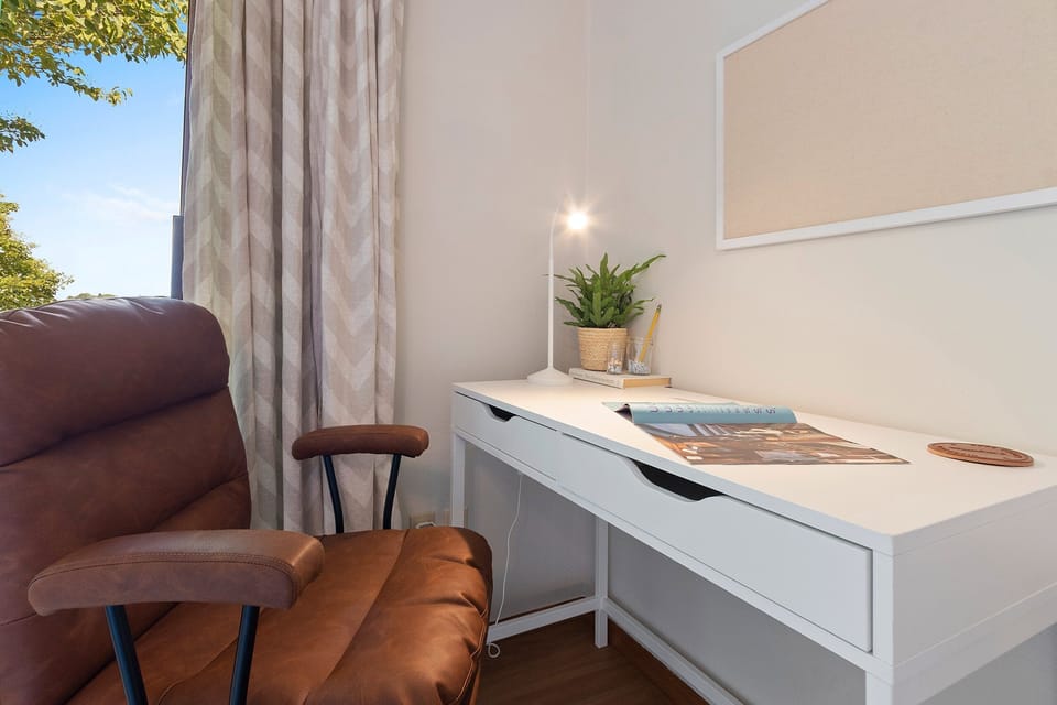 Workspace with desk, office chair and views of the water in the primary bedroom.