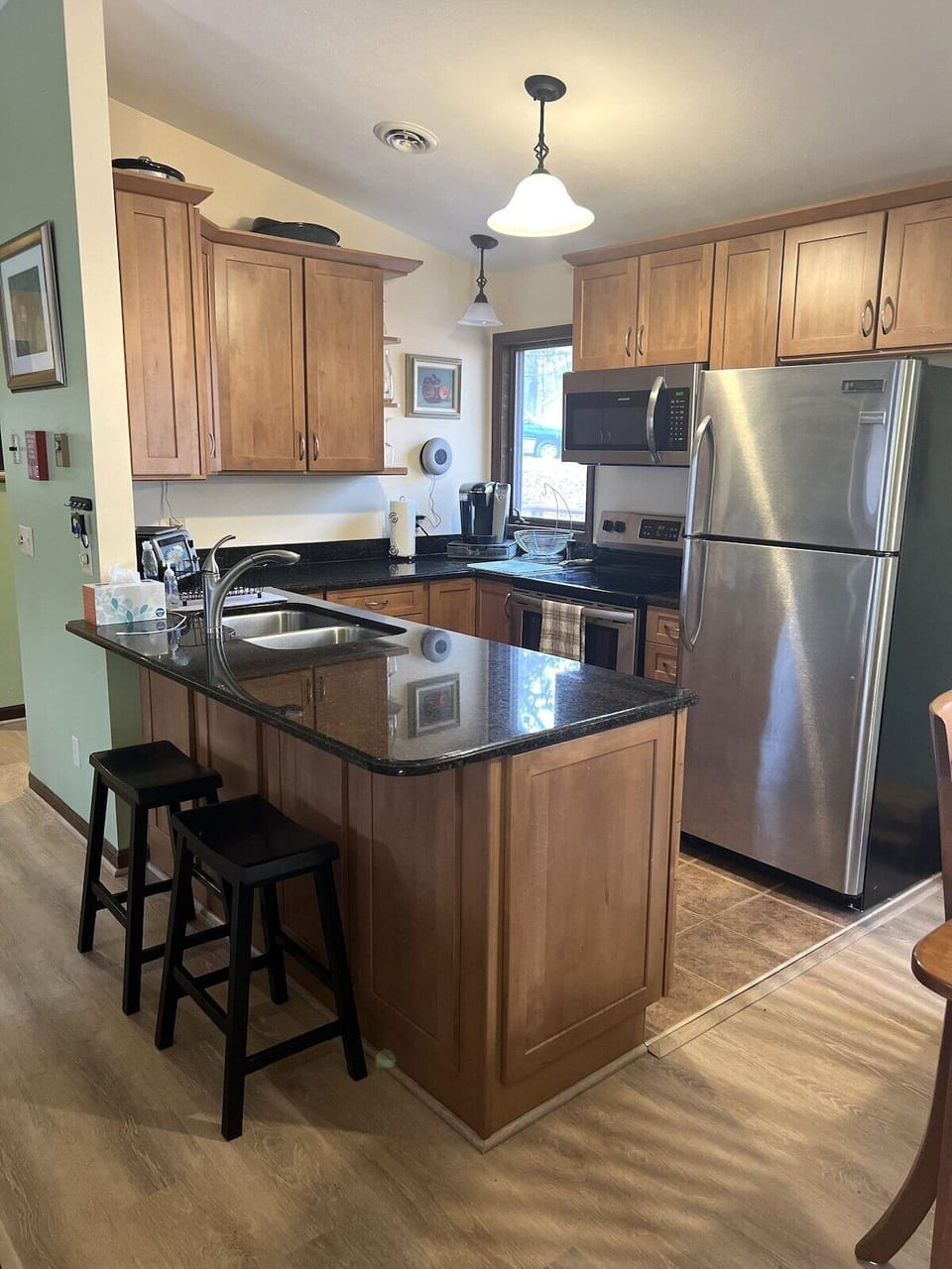 Second view of the eat in bar and kitchen with stainless steel appliances 