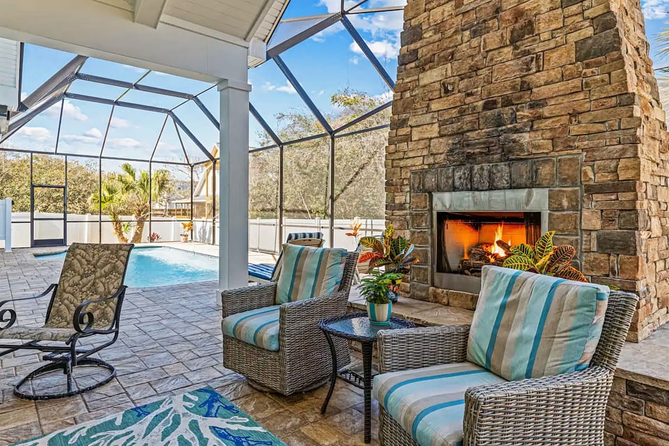 Resort-style outdoor lounge with electric fireplace vibes 🔥🌴
Kick back by the stone fireplace in the screened lanai while the pool sparkles nearby—perfect for cozy nights, morning coffee, and unforgettable Florida evenings.
