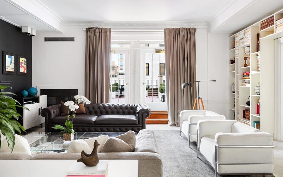 Relax on designer seating with sunlit terrace doors nearby.