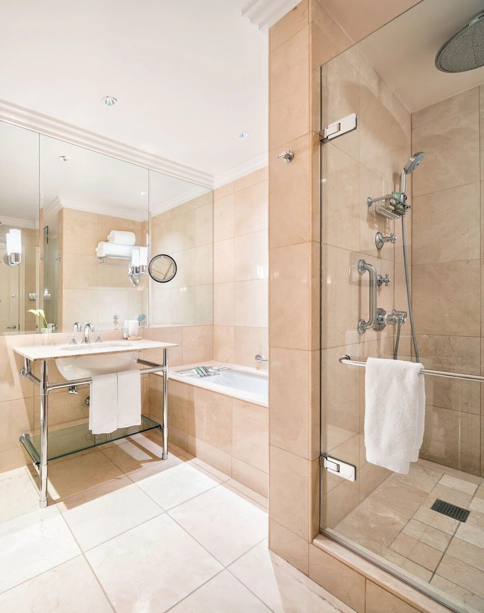 Step into a roomy walk-in shower with polished stone finishes.