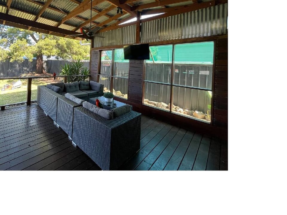 Back deck comes with a dining table, sofa, TV and ceiling fans.