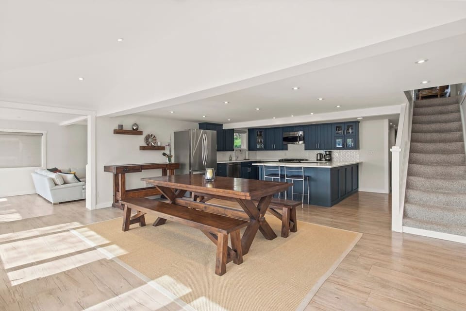 Spacious and modern open-concept kitchen and dining area with rustic wooden furniture. Perfect for cooking and enjoying meals together, with plenty of natural light and a welcoming atmosphere.