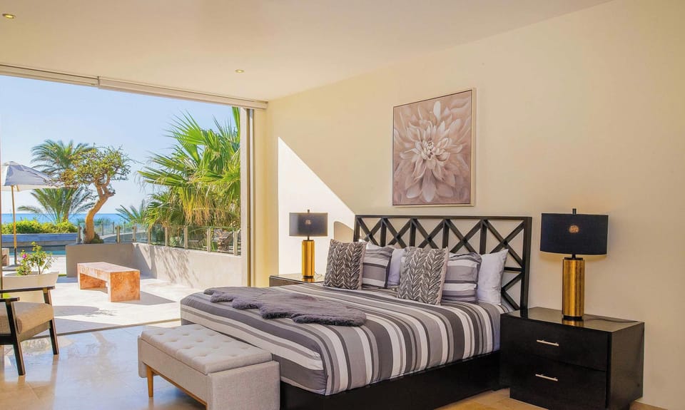 Stylish bedroom with king bed, direct outdoor access, and garden views.
