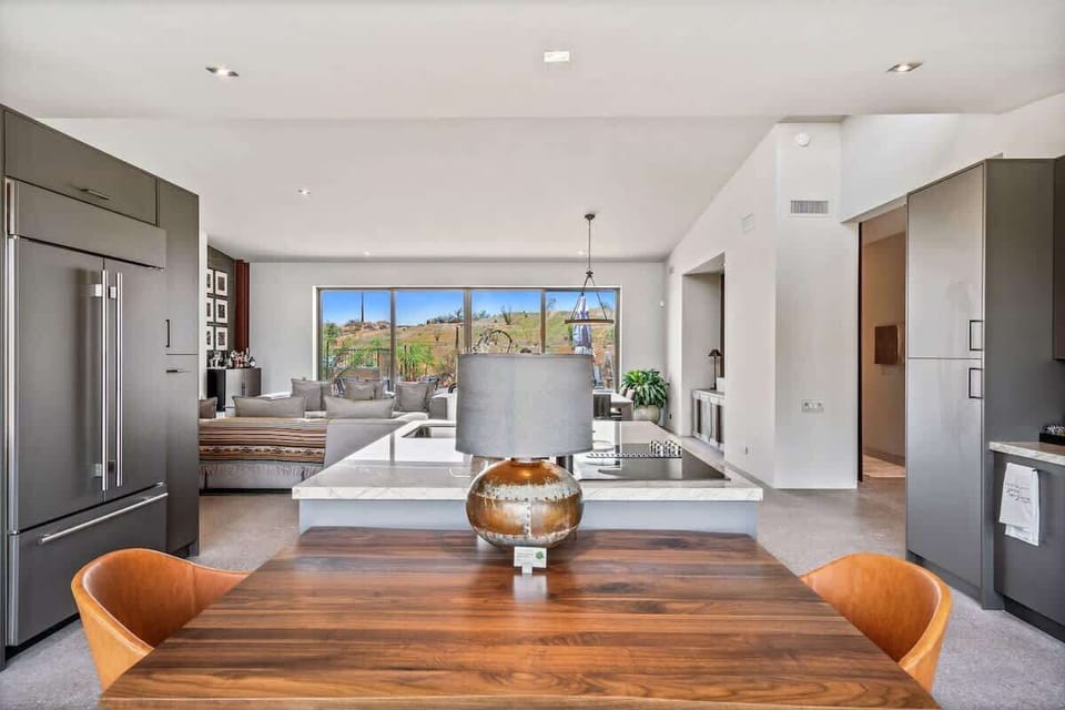 Estate 1: Fully equipped luxury kitchen stocked with all culinary essentials and features high-end stainless-steel appliances, a kitchen island, a breakfast table, and a wet bar / coffee station.