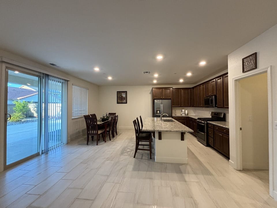 Fully kitchen with granite countertop, island, stainless steel appliances.