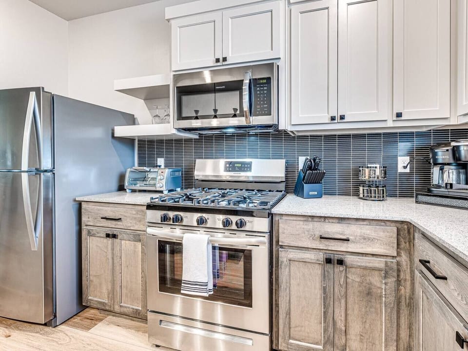 “Sleek and Functional: Modern kitchen with stainless steel appliances, a central island, and stylish bar stools.”