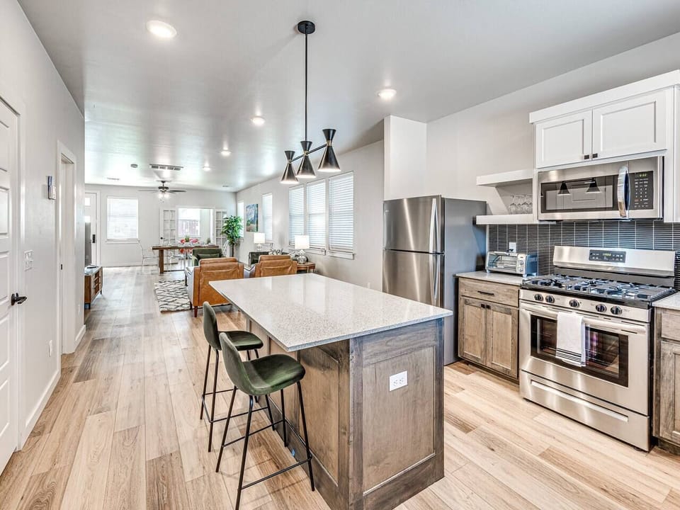 “Step into our kitchen oasis! Our spacious island, adorned with a sleek marble countertop, invites culinary creativity. Whip up gourmet meals or enjoy casual breakfasts at the bar stools. Modern appliances and ample storage make this kitchen a chef’