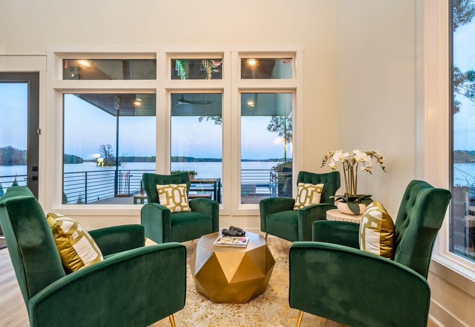 A Comfortable Lounge Area With Velvet Chairs And Floor-to-Ceiling Windows Offering Natural Light.