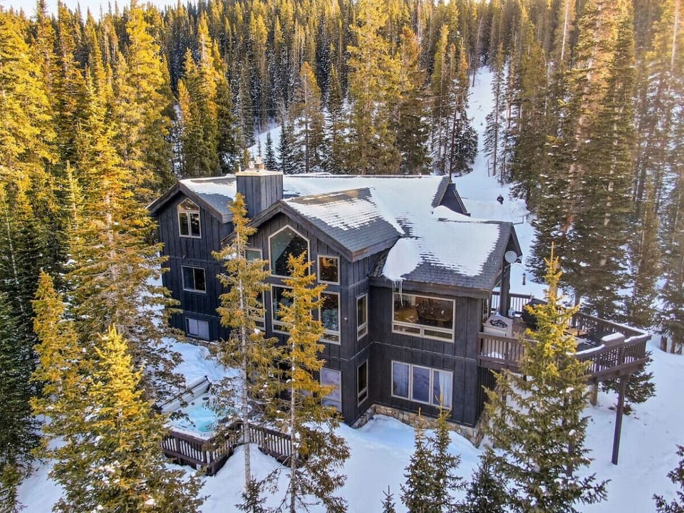 Large home with a spacious deck and ground level, outdoor hot tub