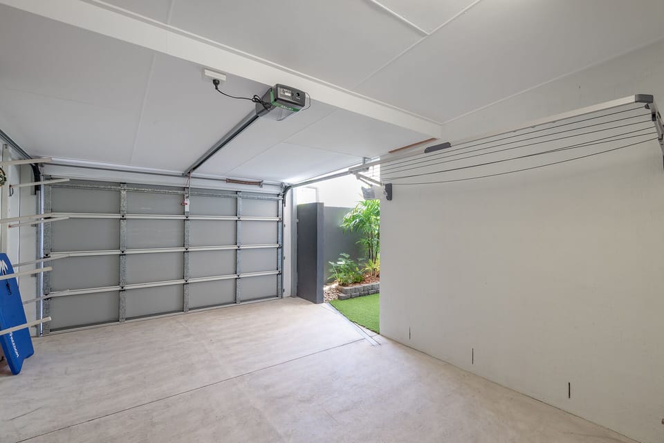 Private garage with direct indoor access, accommodates small car only.
