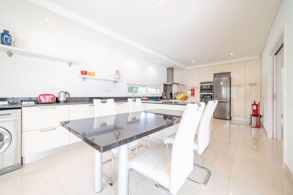 Modern open-plan kitchen with dark granite island — Villa Mirage, holiday villa in Verdizela
