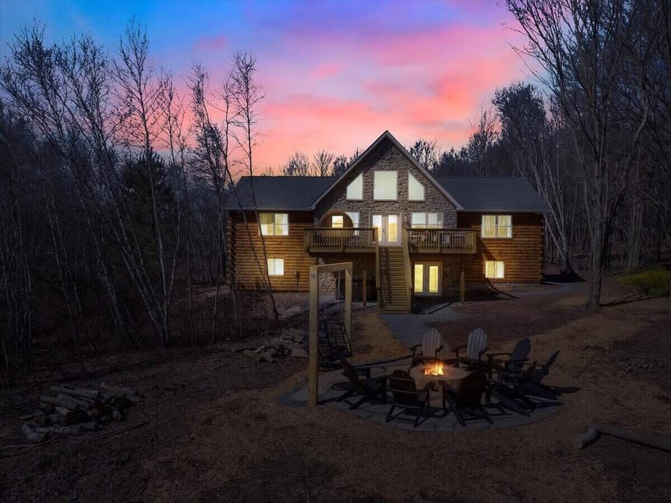 Luxury Log Cabin Exterior at Sunset with Fire Pit