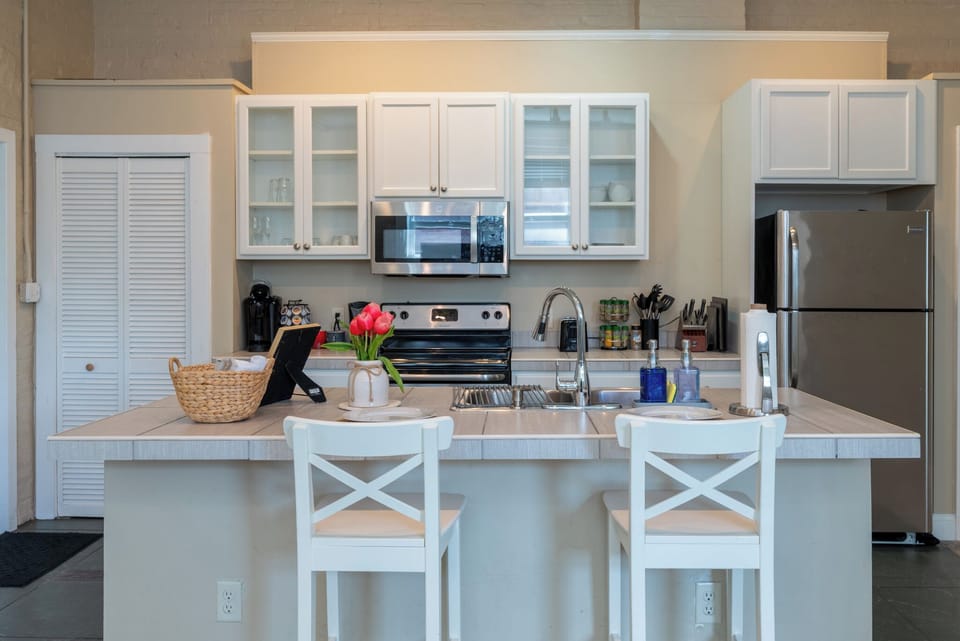 Enjoy meals or a glass of wine at the kitchen island with comfortable bar seating in the heart of the apartment.