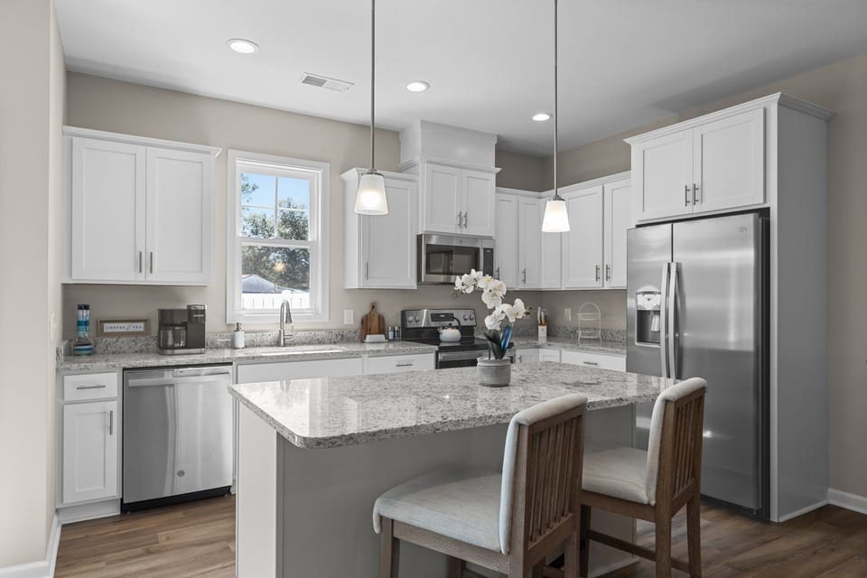 Sleek, open kitchen: inviting island, stunning countertops, morning coffee.