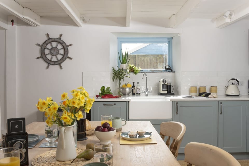 A dining table and kitchen - School Cottage