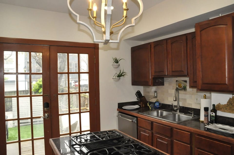 The kitchen has an island stove and French doors reveal the back garden.