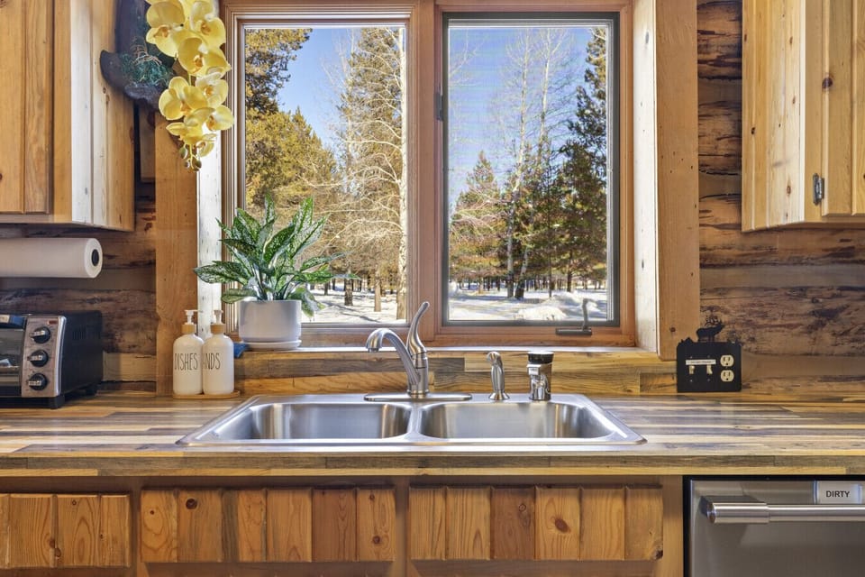 Kitchen with pine cabinetry, stainless sink, and natural light from the window