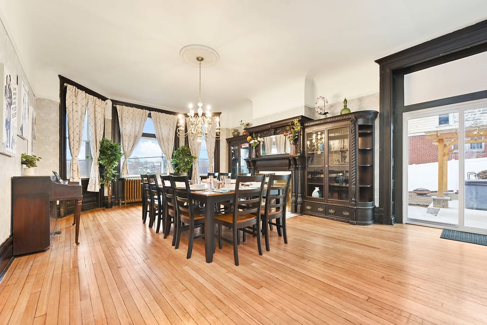 Grand dining room seats 12 w/ chandelier, tall windows & patio access.