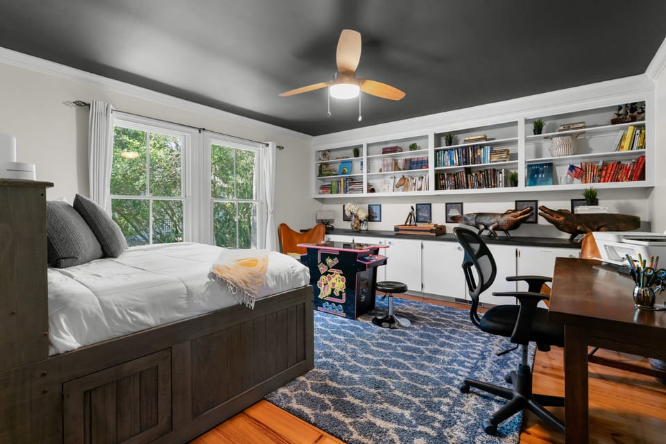 This versatile space features a cozy bed, a full library, and a dedicated workspace for guests.
