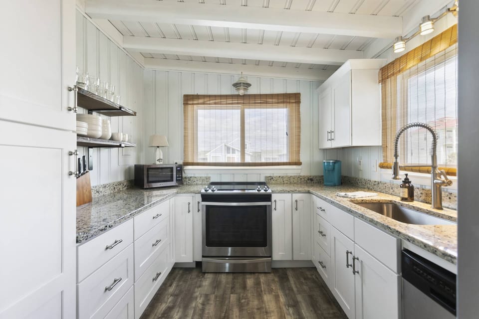 Bright and modern kitchen featuring white cabinets and stainless steel appliances.
