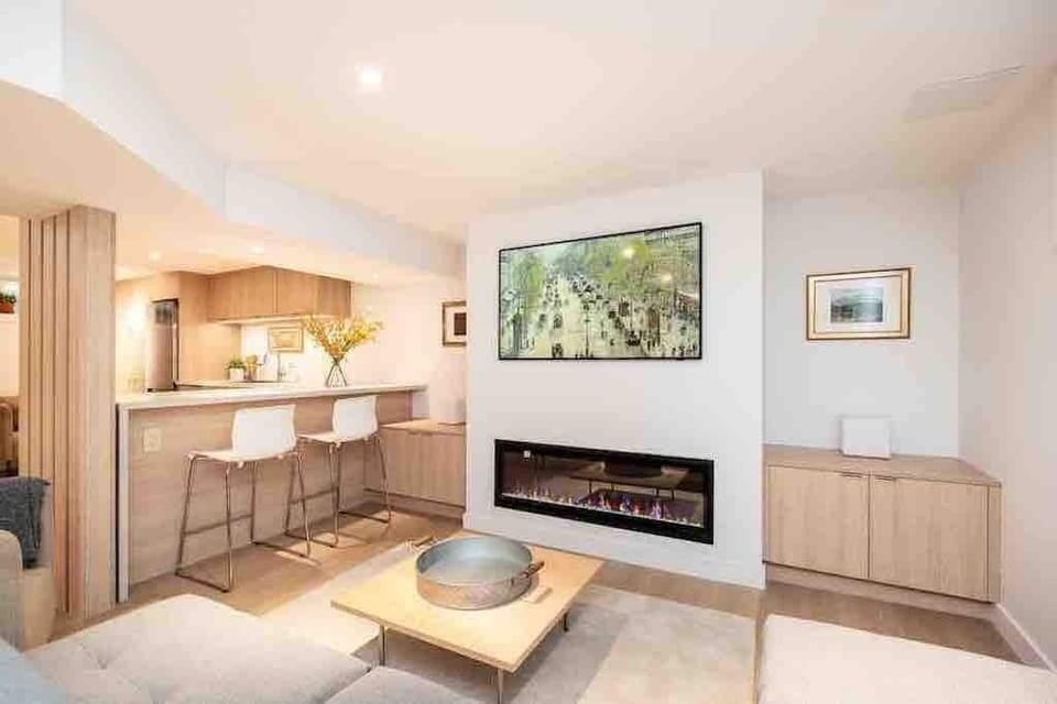 The living area with fireplace has 54" smart TV.  Island bar stools are close by