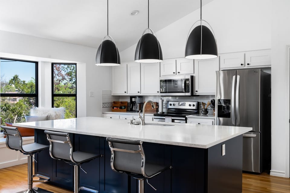 Kitchen with a large island with 3 hanging ceiling lights