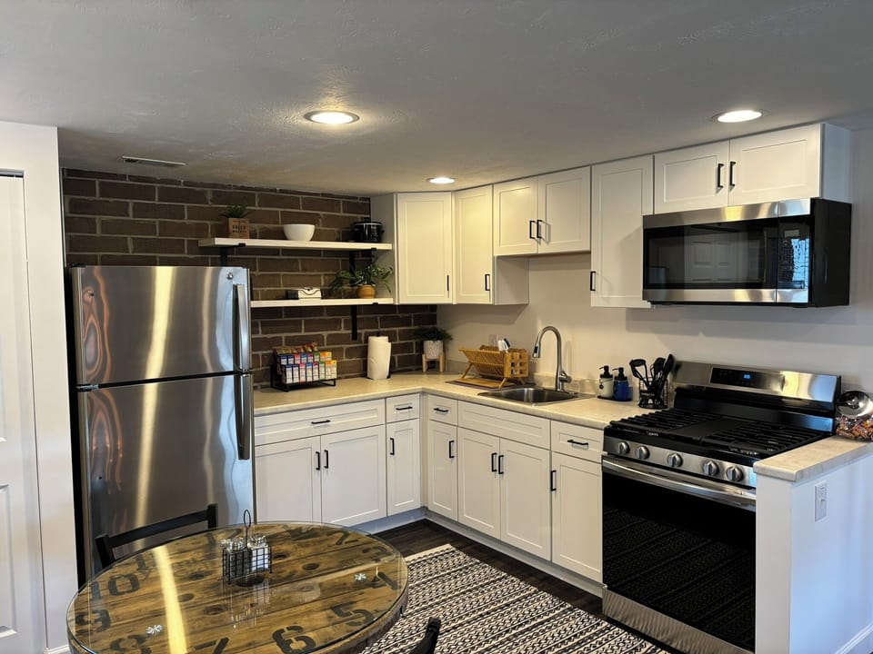 Full kitchen, including breakfast bar and unique clock-wheel dining table. 