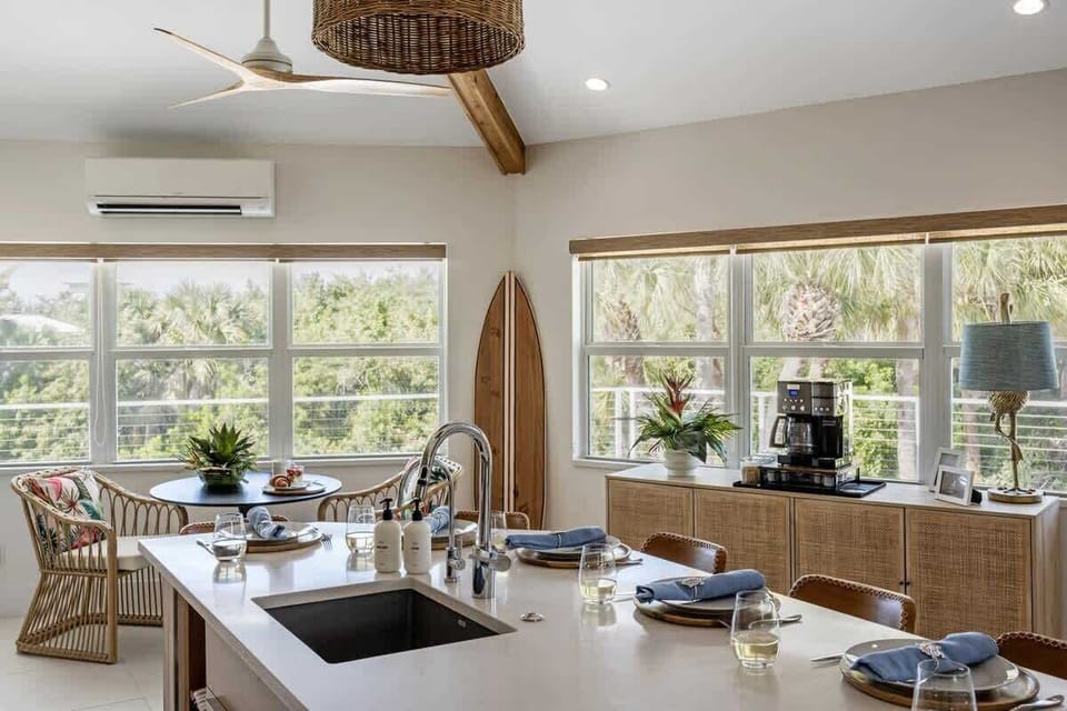 Step through the front door into a spacious open-concept living area, where vaulted ceilings and large windows create an airy ambiance filled with natural light.