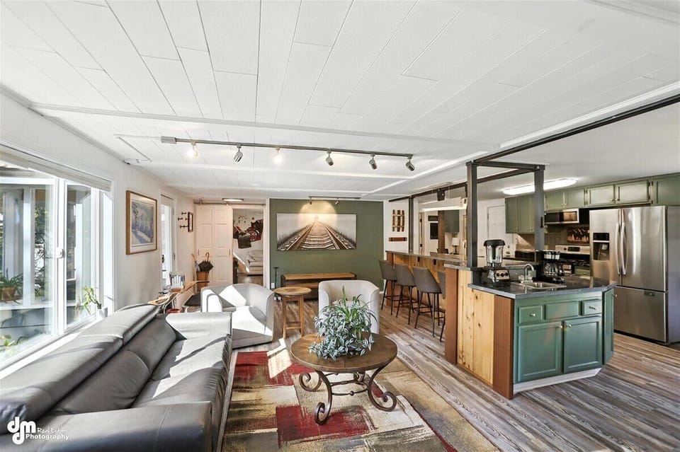 View from fireplace captures living room, kitchen, custom island and coffee bar