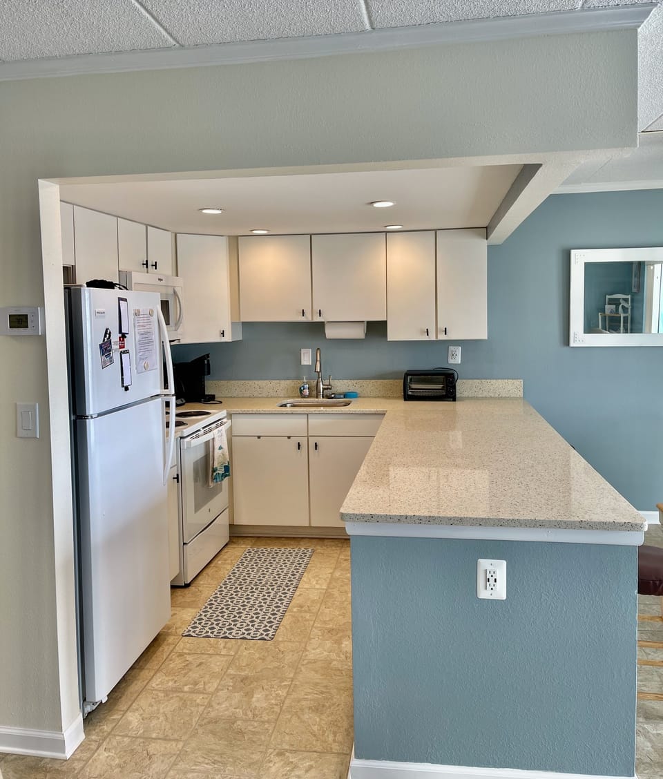 Stocked kitchen with microwave, oven, dishwasher, coffee maker, Keurig, cookware