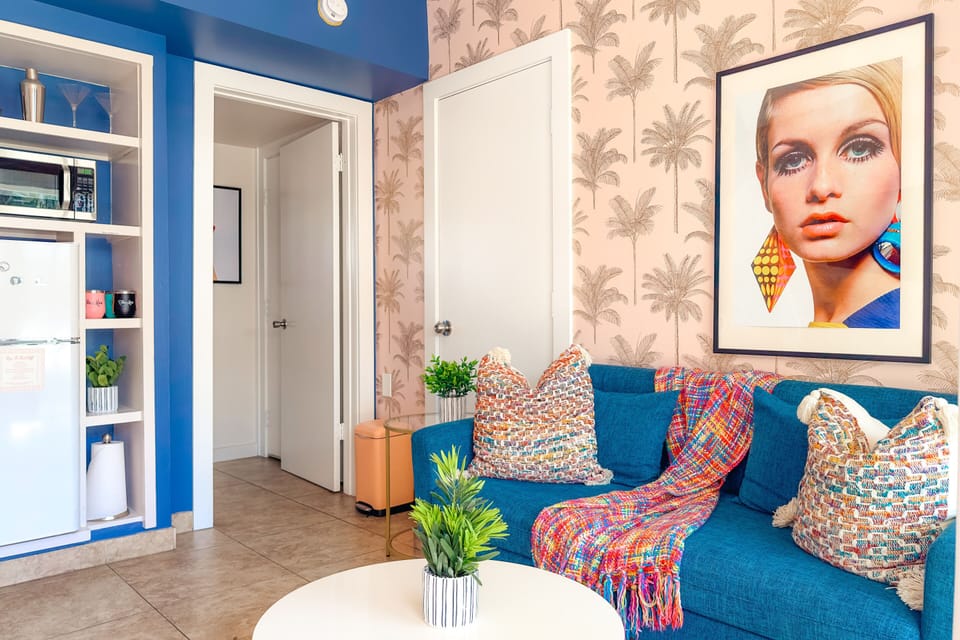 Chic Living Area: Relax in style! Enjoy the tropical-chic decor, comfortable seating, and direct access through sliding glass doors to the sunny outdoors.