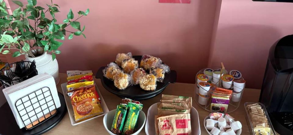 Complimentary Grab & Go Breakfast featuring fresh muffins, coffee, tea, cereal, fruits, and oatmeal. The perfect start to your stay!