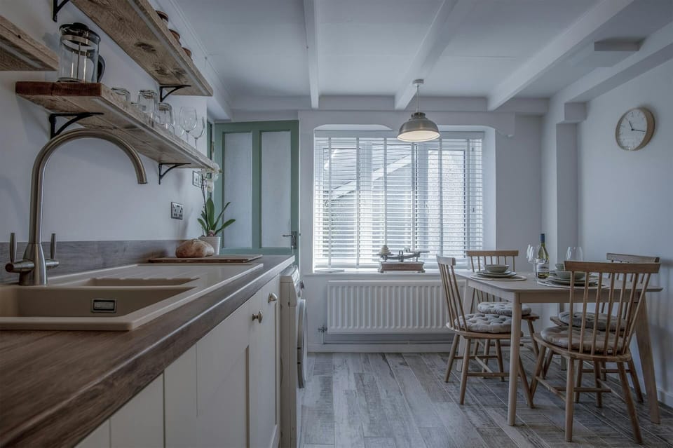 kitchen view facing window and wooden dining set