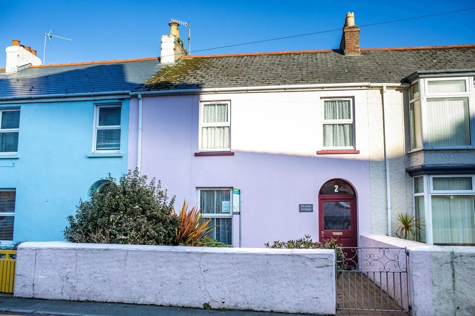 Pink cottage with red door. Front garden with gate