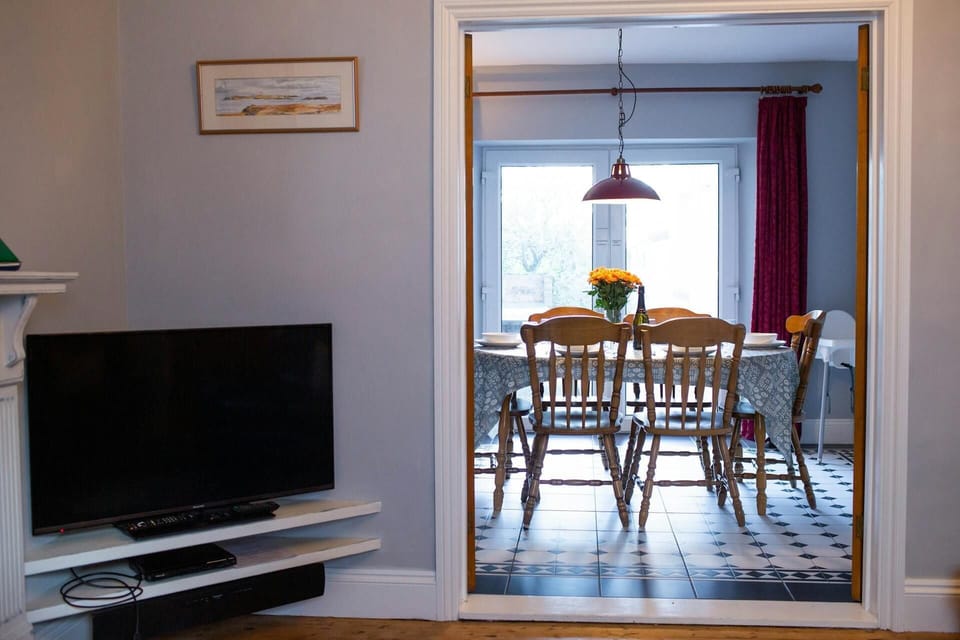 Double doors open leading to dining room with table and chairs