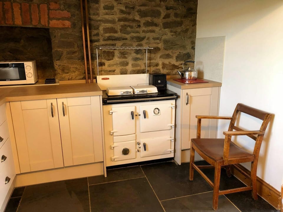 Range cooker, microwave, kettle and wooden chair