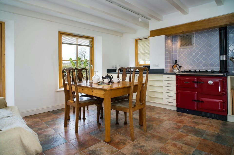 Dining/kitchen: dining table and four chairs and Rayburn stove behind