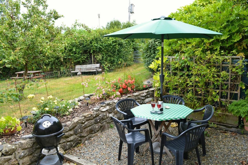 Outdoor table and chairs with parasol. BBQ and views over the garden