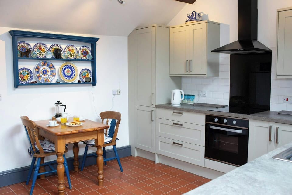 Kitchen table and two chairs. Wall mounted plate rack