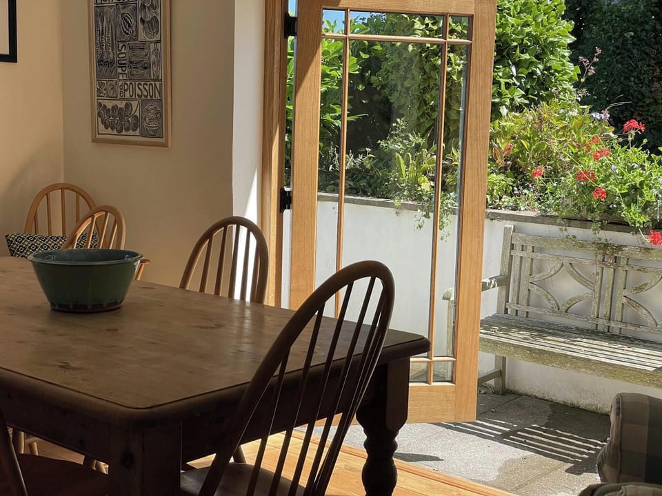 Dining area with table and chairs and double doors leading to the garden