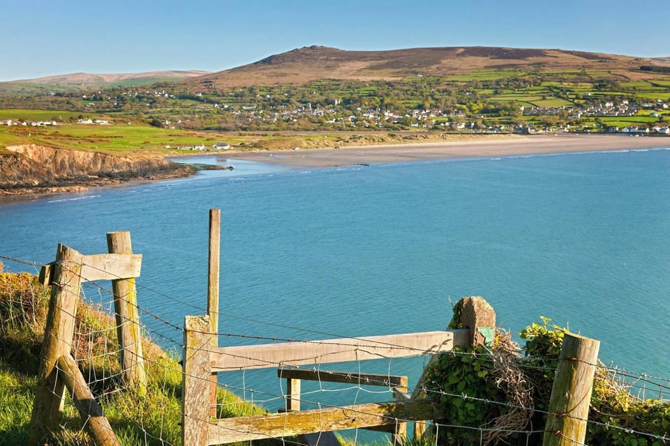 View of Newport bay looking across the sea to the and beach with hills in the distance