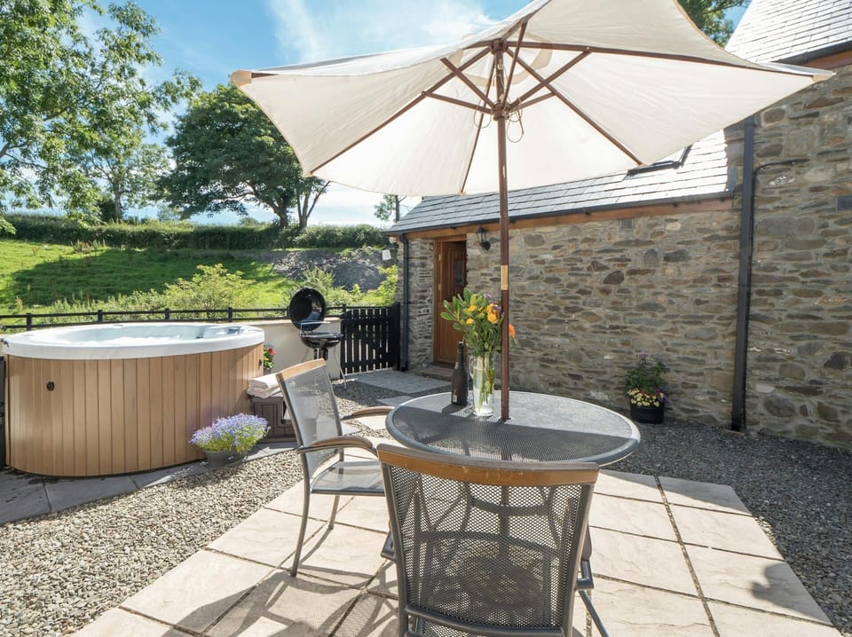 Private patio at Briallen with hot tub, table and chairs