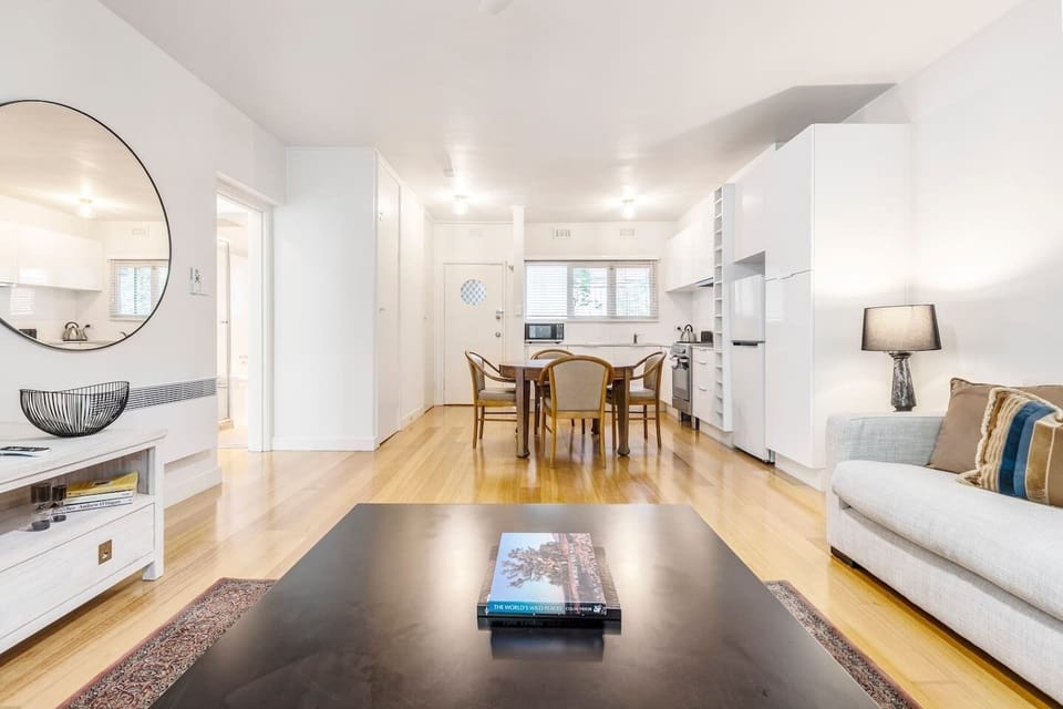 The living and dining area is open plan, with a fresh colour pallette and light, leafy outlooks. 
