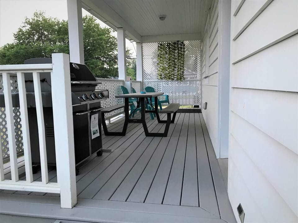Side porch with picnic table and chairs.  Natural Gas Weber BBQ.